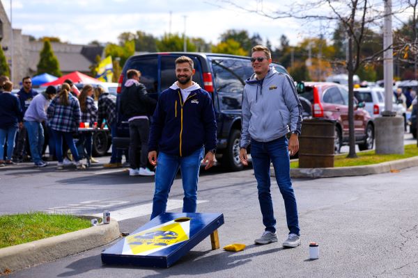 A photo of two Toledo fans playing a game of cornhole before a football game.